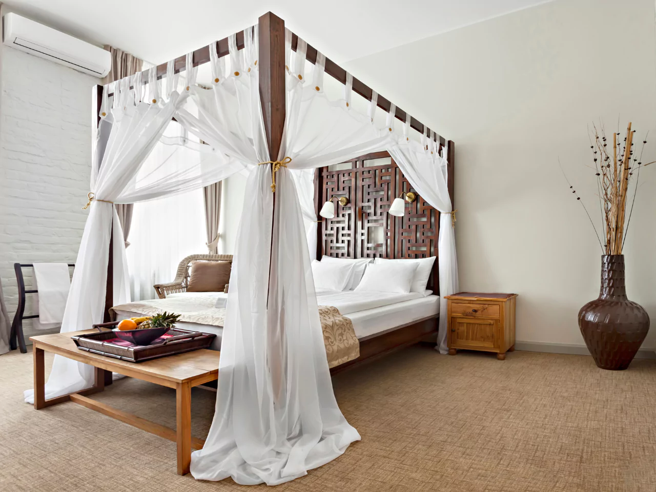 Tempat tidur canopy dengan tiang kayu dan tirai putih yang elegan di kamar tidur klasik.